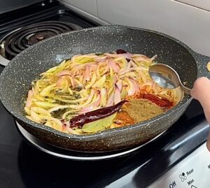 spices are poured in the onion mixture